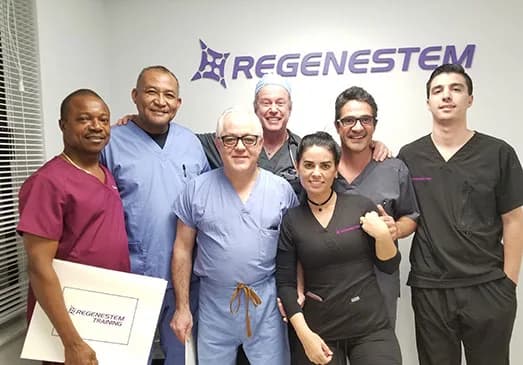 Regenestem staff in scrubs standing under the Regenestem sign, from the clinic's About Us page